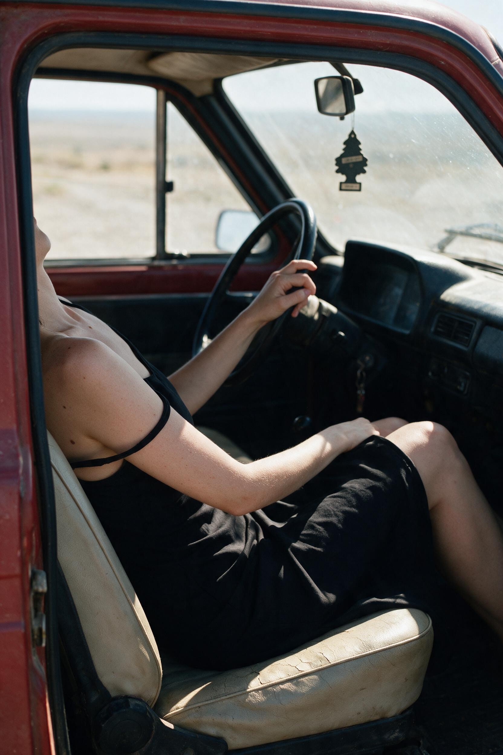 A slipped strap in the Niva's driver seat, sun cutting low through the windshield.
