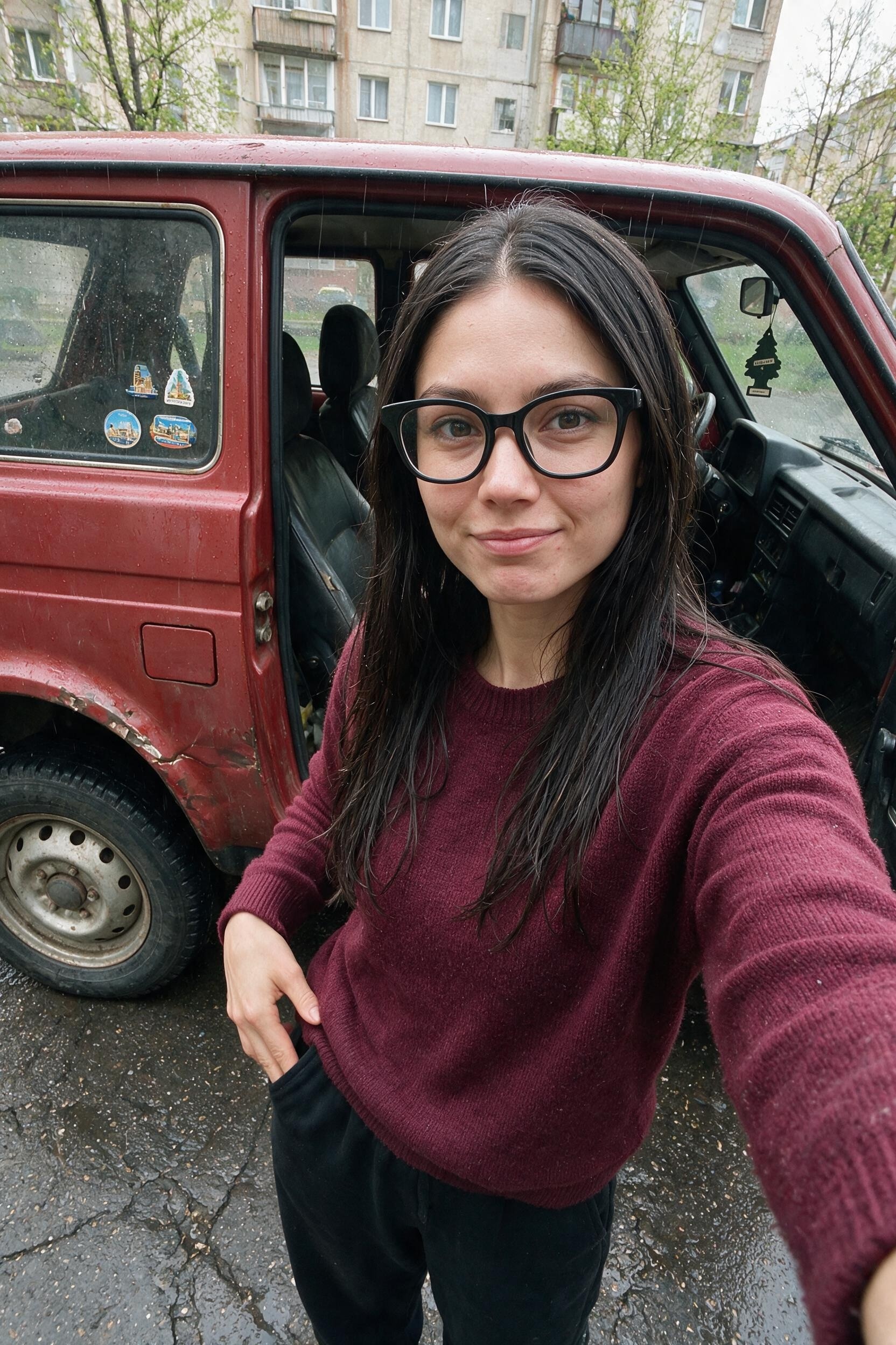 Me by the red Niva, checking empty pockets on a cracked street.
