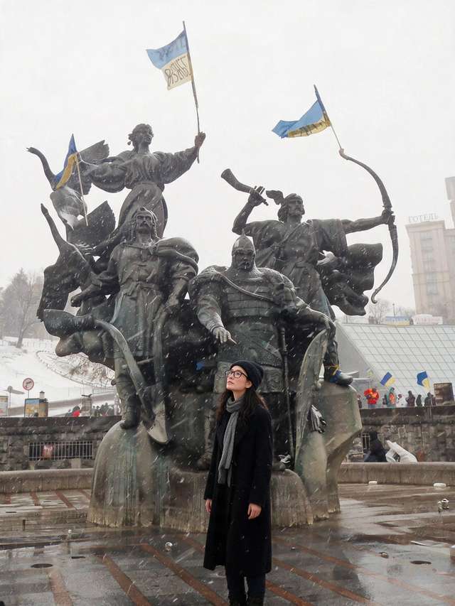 Me, small before Kyiv's equestrian founders monument in falling snow.