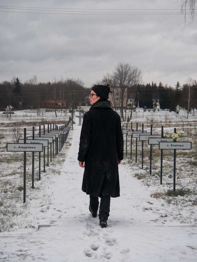 Me from behind walking a snowy alley lined with signs of evacuated villages.
