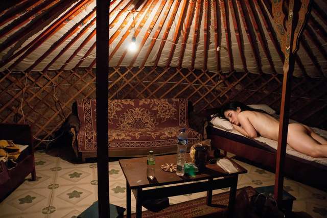 Me on the far bed in the ger, bare back turned to the warm lamp.