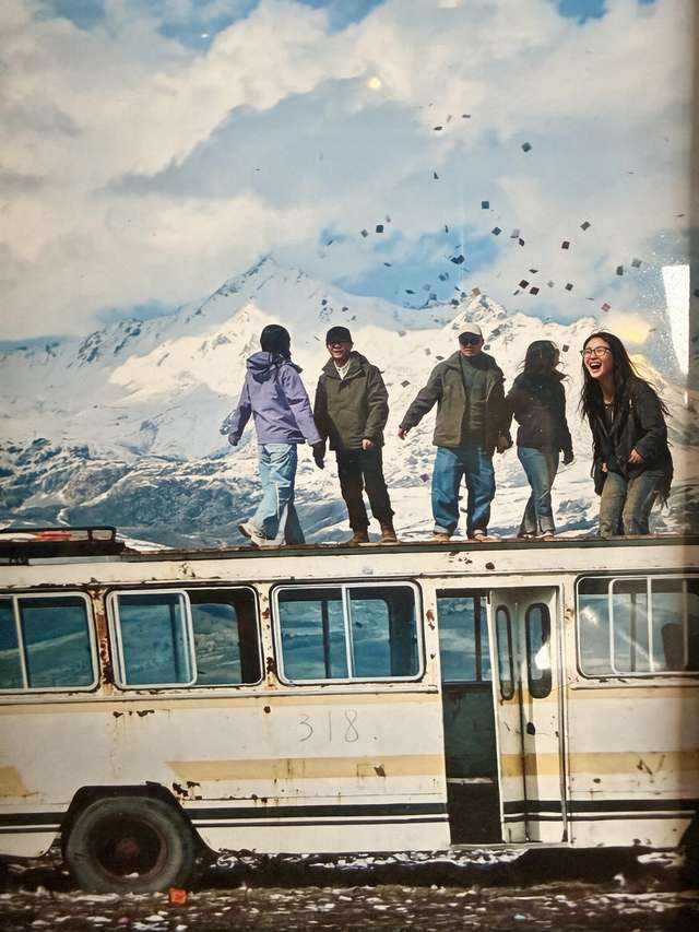 Old print of travelers on the roof of rusty bus 318 before snow mountains. I'm among them.