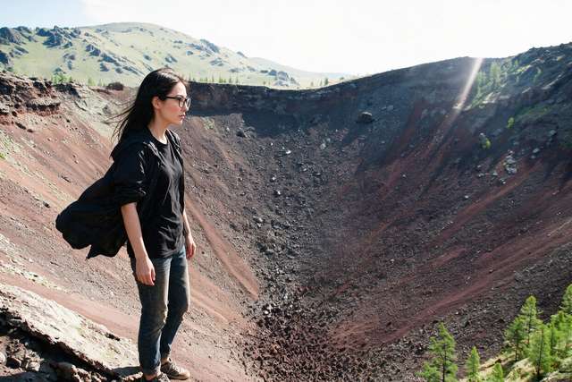 Me small on the rim of the Khorgo crater, red-black bowl below.