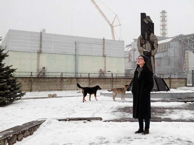 Me at the liquidators' monument near the plant, two stray dogs in the snow beside me.