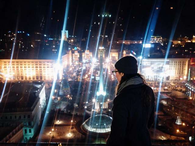 Me from behind at a railing above the lit Maidan Nezalezhnosti at night.