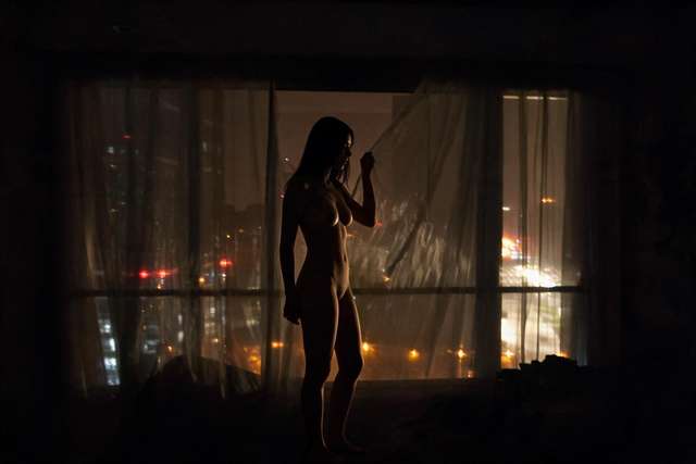 Me, dark silhouette at the sheer curtain. Ulaanbaatar lights beyond.