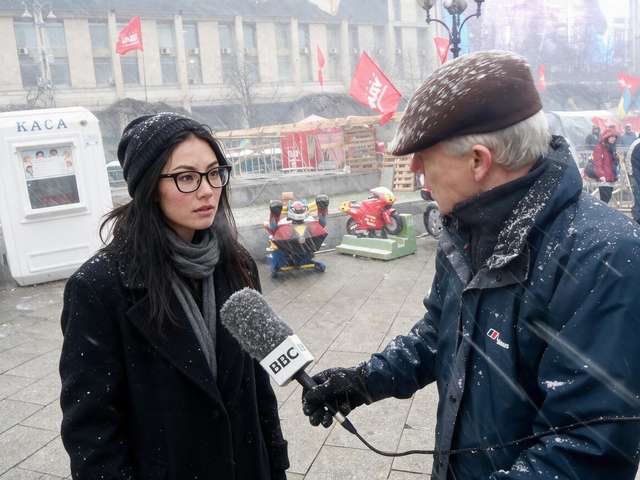 Me interviewed in falling snow by a journalist with a BBC mic at the memorial camp.